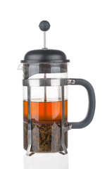 French press with fresh tea close up on white background