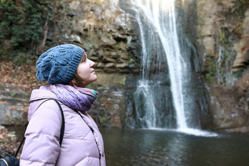 Fototapeta na wymiar Woman posing on background of waterfall
