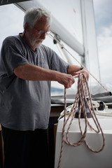 White bearded sailing senior, experienced skipper on a sailboat