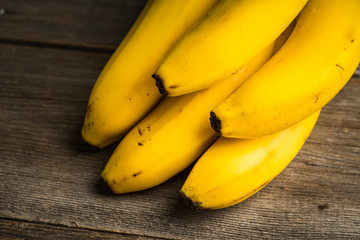 Branch of bananas on the rustic background. Selective focus. Shallow depth of field.