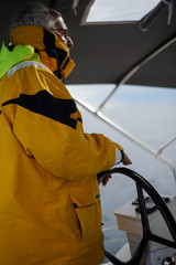 White bearded sailing senior, experienced skipper on a sailboat
