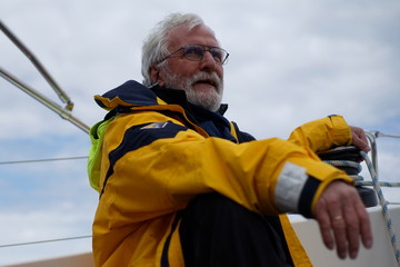 White bearded sailing senior, experienced skipper on a sailboat