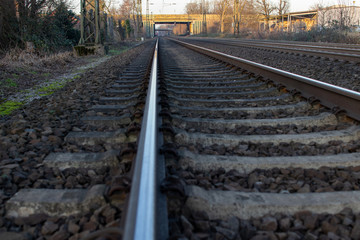 Fototapeta na wymiar Gleise mit Zug im Hintergrunf 