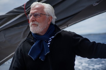 White bearded sailing senior, experienced skipper on a sailboat