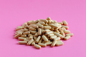 Drugs or pills on pink background. Medicinal tablets, capsules, pills.