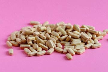 Drugs or pills on pink background. Medicinal tablets, capsules, pills.