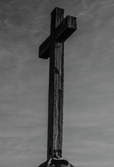 cross in the middle of a mountain receiving the sun's rays
