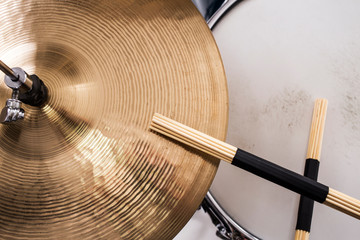 Closeup of drumsticks lying on the drum set