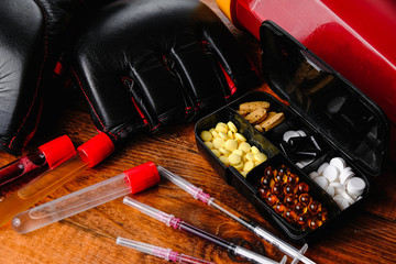 mma gloves and steroid medication with sport nutrition composition on a wooden background