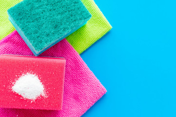 Cleaning powder on a red dishwashing sponge on a household towel on a pink background. The concept of homework.