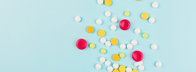 Colorful pills on a pastel blue background. Flat lay, top view, overhead, mockup, template. Pharmacy and medical concept