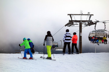 Skifahrer und Snowboarder auf Skipiste mit Skilift im Hintergrund im Skigebiet Felderg im Schwarzwald