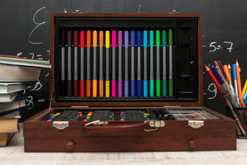 Set of colorful pencils. School supplies in wooden box. Education concept.