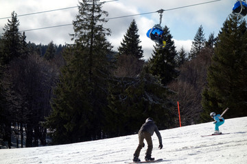 Skifahrer und Snowboarder am Skihang mit Lift im Hintergrund im Skigebiet Feldberg im Schwarzwald