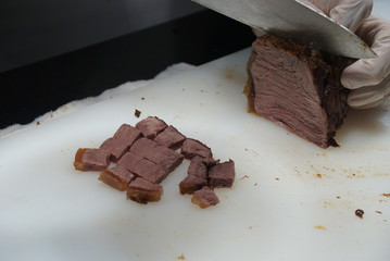 The roasted beef ws being cut and served by the chef