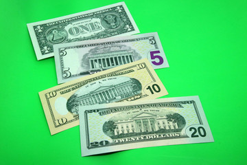 American paper money background. Banknotes in denominations of 1, 5, 10 and 20 dollars in a bright green color background. Back side of USA dollars.