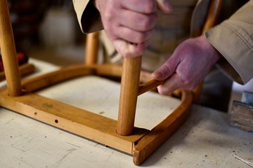 man repair old wooden chair