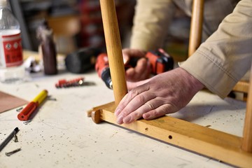 man repair old wooden chair