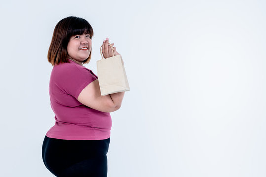 Portrait images of Asian fat woman standing and Holding a paper bag on white background, concept to Global warming reduction campaign By using paper bag replacement plastic bag