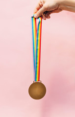 Medal with colorful ribbon hung in hand