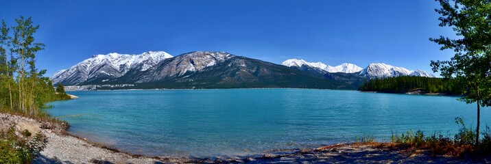 Beautiful blue Abraham Lake with high mountains covered with snow in the background. Sunny day,...