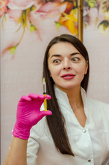 female doctor holds medical syringe in front of her