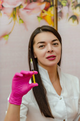 female doctor holds medical syringe in front of her