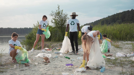 Ecology and environment. View of hardworking young students of eco movement picking up trash waste...