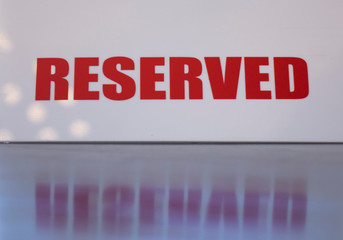 A sign that says reserved on a table in a restaurant or cafe, selective focus.