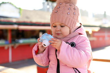Cute little photographer with toy camera outdoors