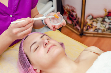 Beautician prepares gel for applying on the face of a patient