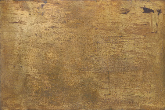 rusty golden metal surface with yellow and orange tones - worn steampunk background with screws and scratches