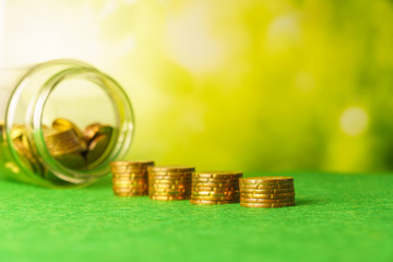 growing growth saving money. money stack step up with blurry coins in bottle against blurry nature background. financial business investment concept. free copy space for text.