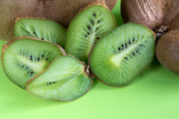 Big ugly vegetable organic kiwi on a green background. Sweet fruit slices. Ugly food concept.