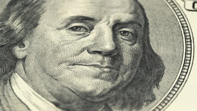 Benjamin Franklin portrait on US 100 dollar bill rotating. Low angle, macro. 4K, 422 10 bit