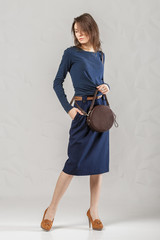Stylish fashionable woman with brown round bag