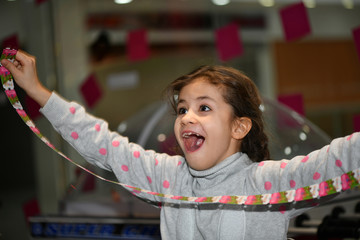 beautiful young girl enthusiastically plays in the children's play area