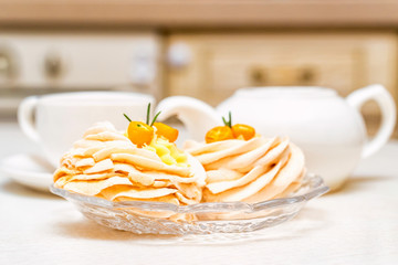 Meringue cake decorated with kumquat and tea