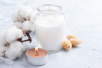 Cotton flower and candle in glas bottle