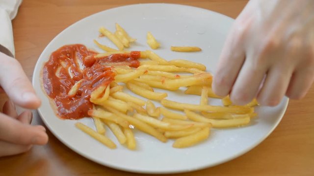 Lunch finish, Hands sharing delicious french fries lunch end served on a large plate with ketchup front view