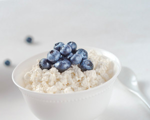 cottage cheese with blueberries on a white plate in a white bowl