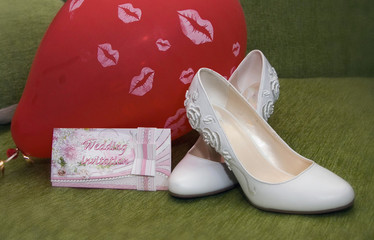 Wedding still life-shoes of the bride, wedding invitation and ball
