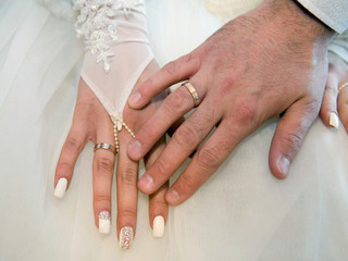 The bride and groom on their wedding day exchange wedding rings.