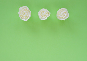 Fototapeta na wymiar white roses on a green background. Festive background for Valentine's day