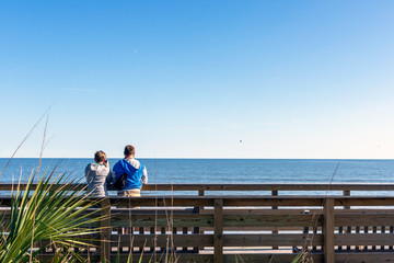 A couple enjoying the ocean view on Jekyll Island, Georgia, a popular slow travel tourism destination in the southeastern United States.
