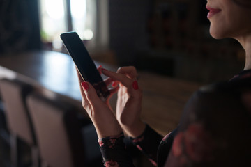 Young woman holding phone in hands. Close up picture