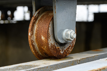 The platform wheel as a rusty condition because of it was left for a long time, the concept of urban exploration. Close and select focus on the metal wheel.