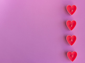 Hearts on the pink background. Candles in the shape of hearts. Happy Valentines Day. 14 February, women's day, March 8. Top view. Flat lay. Greeting card. Copy space for text.