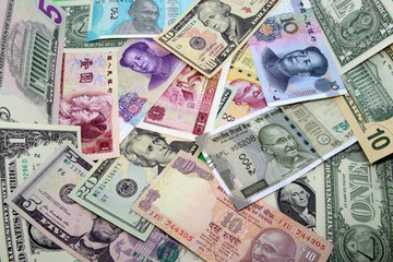 Fototapeta na wymiar Assorted paper money background. Mix of American, Chinese and Indian colorful banknotes.