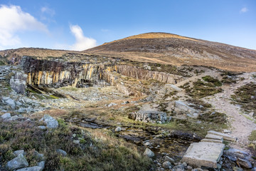 Fototapeta na wymiar Old stone quarry in Mourne Mountains on the hill of Slieve Donard mountain. This mountain range is the highest and most dramatic in Northern Ireland.